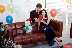 Sweet couple Love smile and spending Romantic for Take a picture with a mobile phone in christmas time and celebrating new year eve, valentine day with colorful balloons in living room photo