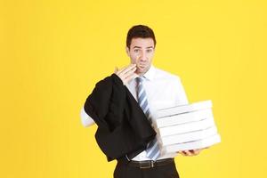 Handsome and smart businessman in suit and white shirthand holding document books isolated on yellow background. Copy Space photo