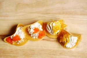 Thai Crispy Pancake or Kanom Buang on wooden plate isolated on white background photo