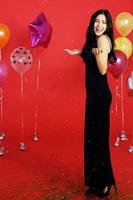 Pretty Woman smile and dancing in christmas, Birthday time and celebrating new year eve with colorful balloon on red background photo
