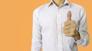 Businessman in white work clothes on a yellow background showing thumbs up to encourage work.Compliments for excellent work, encouragement for success. photo