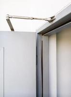 Slim door closer on the metal door. photo