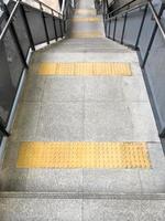 The braille block tile between the landing of the modern staircase for the visually impaired person. photo