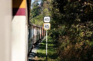 The traffic sign shows the train's limited speed, climbing to the high mountain with the diesel-electric locomotive. photo