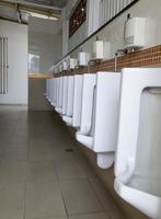 fila de urinarios blancos foto