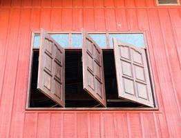 Wooden window is opened from the countryside house. photo