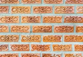 Red brick with the flower pattern on the concrete wall. photo