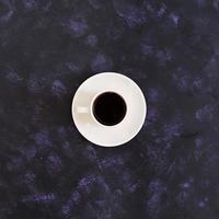 Cup of coffee on dark background. Top view photo