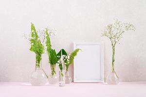 Flowers and plants in flask with frame. Beautiful spring background with flowers in vase. photo