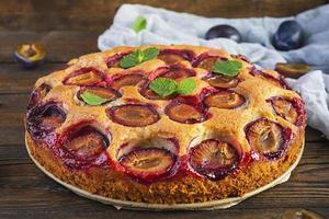 Delicious homemade plum pie on rustic background photo