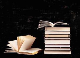 Stack of different books on dark background. Knowledge concept. photo