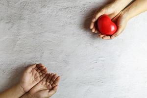 corazón en la mano dando el concepto de donación de corazón. foto