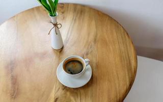 Hot black coffee on a wooden table in a cafe photo