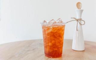 té helado de melocotón en la mesa de madera foto