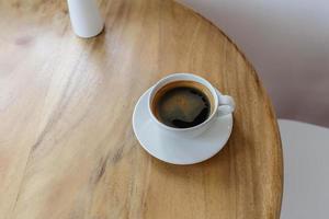 Hot black coffee on a wooden table in a cafe photo