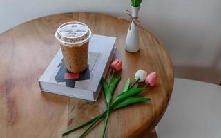 vaso de plástico de café expreso frío en una mesa de café foto