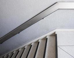 escalera de mármol blanco con pasamanos de metal. foto