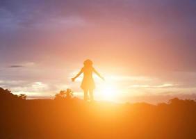 Silhouette of woman praying over beautiful sky background photo