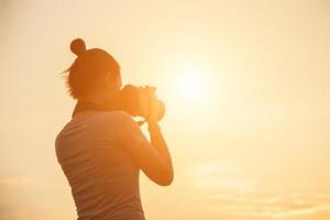silueta fotógrafo mujer en la puesta del sol foto