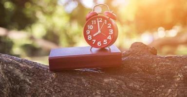 hora del reloj retro a las 8 en punto con cuaderno o memo en la mesa de madera, tiempos de memoria escribiendo el concepto de diario tono de color vintage. foto