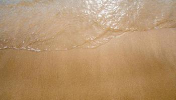 White bubble of Sea wave on the beach photo