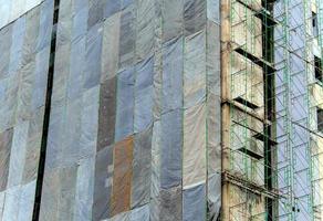 Several large canvases stretch together, Covered building under construction photo