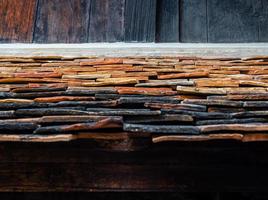 The ancient building roof was shingled with warped clay tiles photo