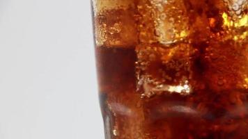 Cola with Ice in glass. Coke Soda closeup. Rotate glass of Cola drink over white background. video