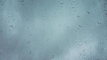 Rain drops running down a window in a close up view. video