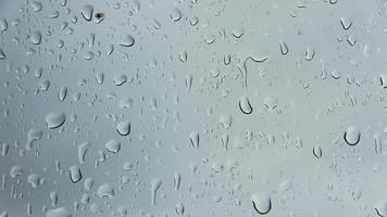 gocce di pioggia che scendono da una finestra in una vista ravvicinata.