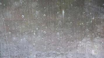 Rain drops running down a window in a close up view. video