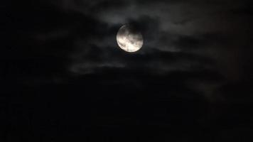 View at the bright moon at night with some clouds passing by. video