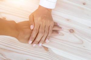 Hands clasped together on table photo