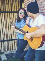 Young hipster man playing guitar to relaxing on his holiday, enjoy with natural and fresh air. photo