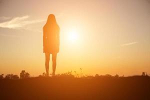 silueta de mujer rezando sobre un hermoso cielo de fondo foto