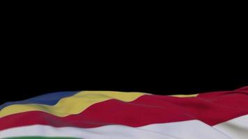 Seychellen stof vlag zwaaien op de wind lus. Seychellen borduurwerk gestikte doek banner zwaaiend op de wind. half gevulde zwarte achtergrond. plaats voor tekst. 20 seconden lus. 4k video