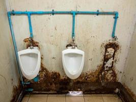 la sucia fila de urinarios del baño temporal en la estación de tren. foto