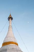 pagoda blanca con el paraguas dorado en la cima. foto