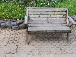 Wooden bench near the flowerbed. photo