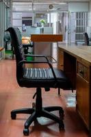 The black leather armchair near the old wooden table in the local office. photo