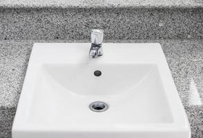 White sink basin on the marble counter. photo