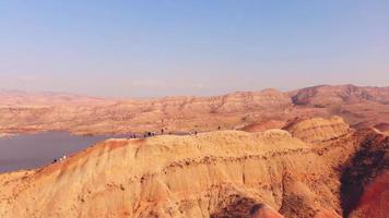 vista aerea passeggiata turistica entusiasta della struttura unica canyon del deserto arcobaleno colorato a mravaltskaro con sfondo del serbatoio. destinazione di viaggio in Georgia, Caucaso video