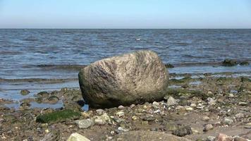 lage hoekmening op watergolven aan de kust van een strand aan de Oostzee op een zonnige dag. video