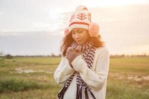 mujer joven estaba jugando en un campo de flores en el aire de invierno. foto