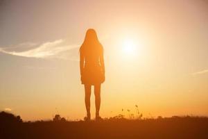 silueta de mujer rezando sobre un hermoso cielo de fondo foto