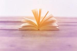 Open book on wood planks over abstract light background photo