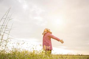 mujer joven estaba jugando en un campo de flores en el aire de invierno. foto