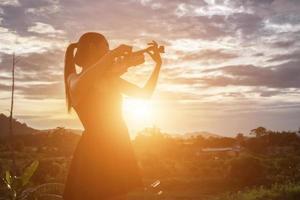 mujer joven tocando el violín con montañas en el fondo foto