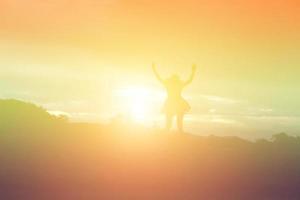 Silhouette of woman praying over beautiful sky background photo