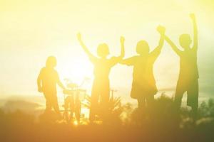 silueta de niños felices y puesta de sol feliz foto